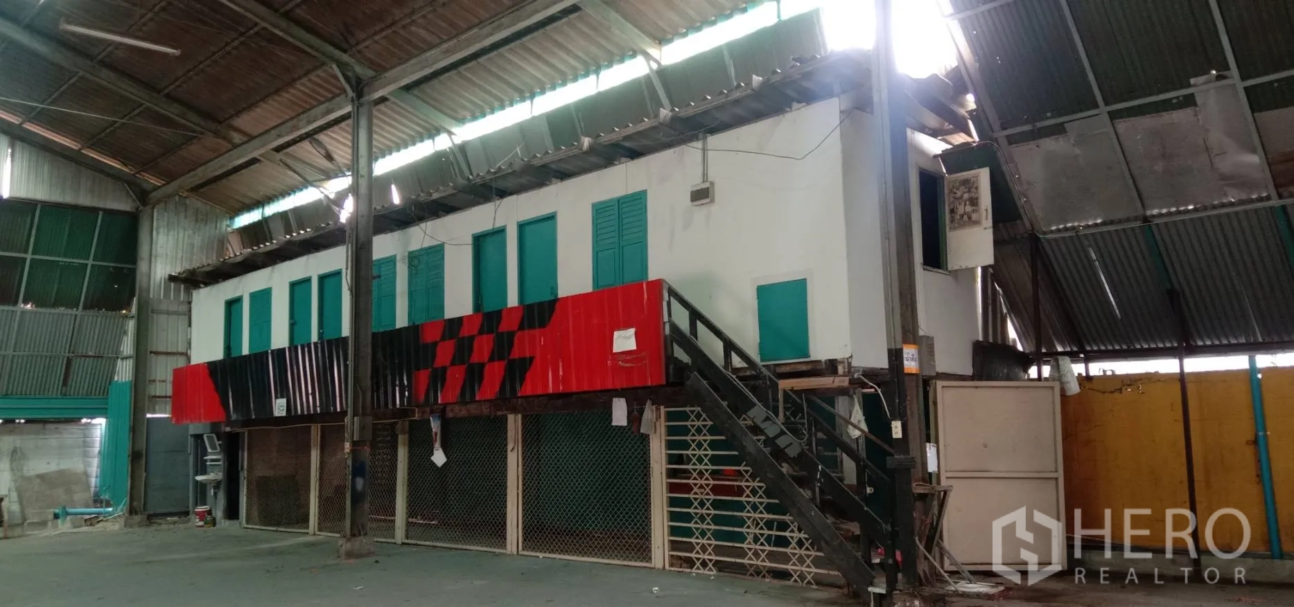 คลังสินค้า ให้เช่าในBueng Kum, Bangkok - มุมมองใกล้อาคารออฟฟิศภายใน มีหน้าต่าง ผนังแต้มสีเหลือง และแผ่นหลังคาโปร่งแสงรับแสงธรรมชาติ