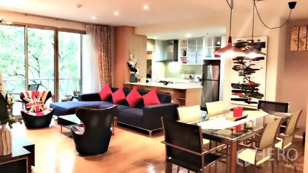 公寓 出租在Bang Rak, Bangkok - 客餐厅一体空间，玻璃餐桌、吊灯、开放式厨房与阳台绿景。