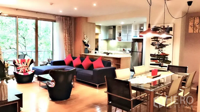 公寓 出租在Bang Rak, Bangkok - 客餐厅一体空间，玻璃餐桌、吊灯、开放式厨房与阳台绿景。