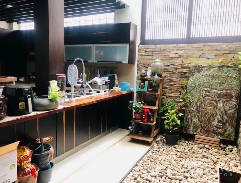 Condominium for rent in Pathum Wan, Bangkok - Kitchen counter facing an indoor pebble garden with plants and decorative bas-relief artwork.