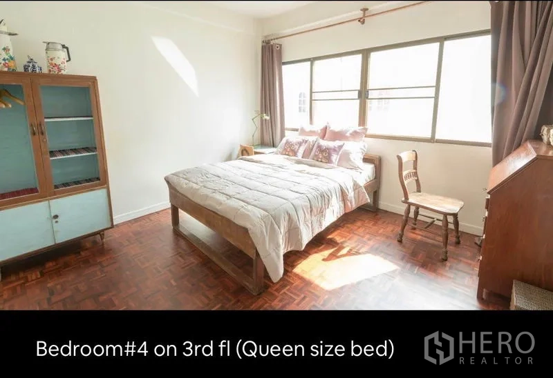 ทาวน์เฮาส์ ให้เช่าในKhlong Toei, Bangkok - ห้องนอนชั้นสามสว่างด้วยแสงธรรมชาติ เตียงควีนไซส์ หน้าต่างบานใหญ่ และตู้วินเทจ