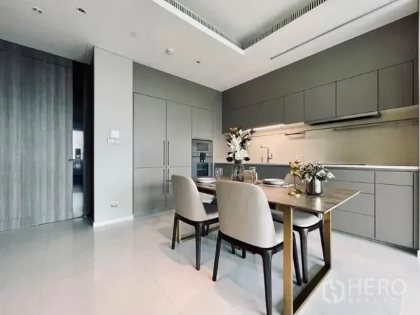 Condominium for rent in Pathum Wan, Bangkok - Bright dining corner beside linear cabinetry with under-cabinet lighting and built-in oven.