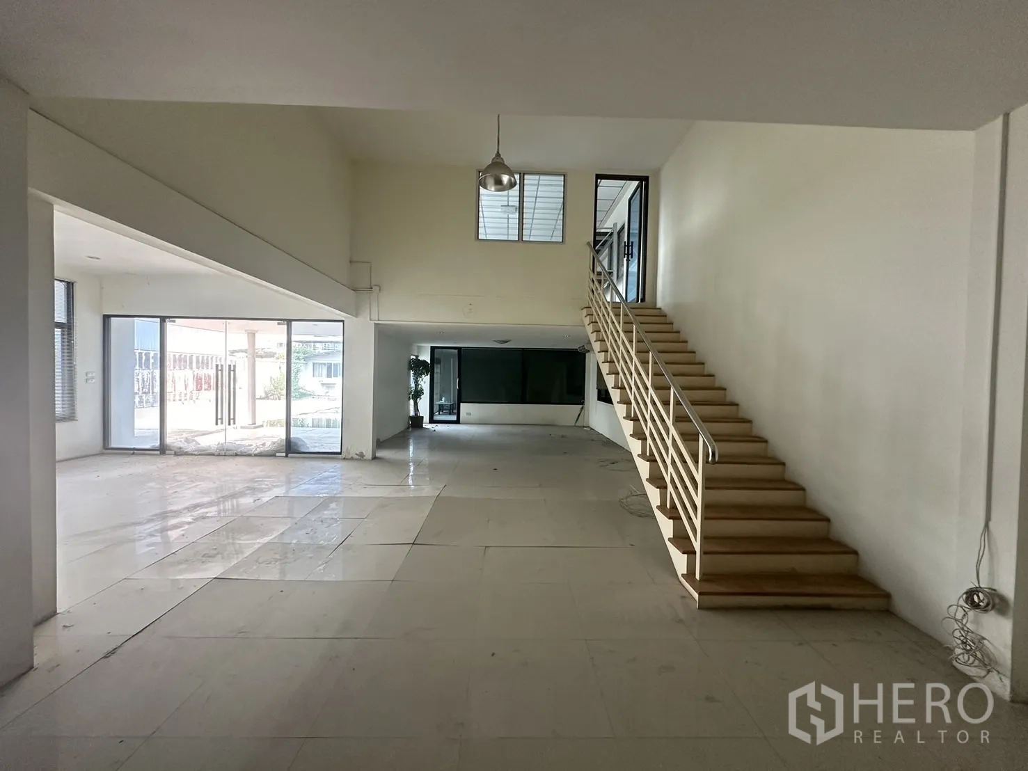 工厂 出租或出售在Prawet, Bangkok - 明亮的办公大厅，瓷砖地面、楼梯与落地玻璃门。