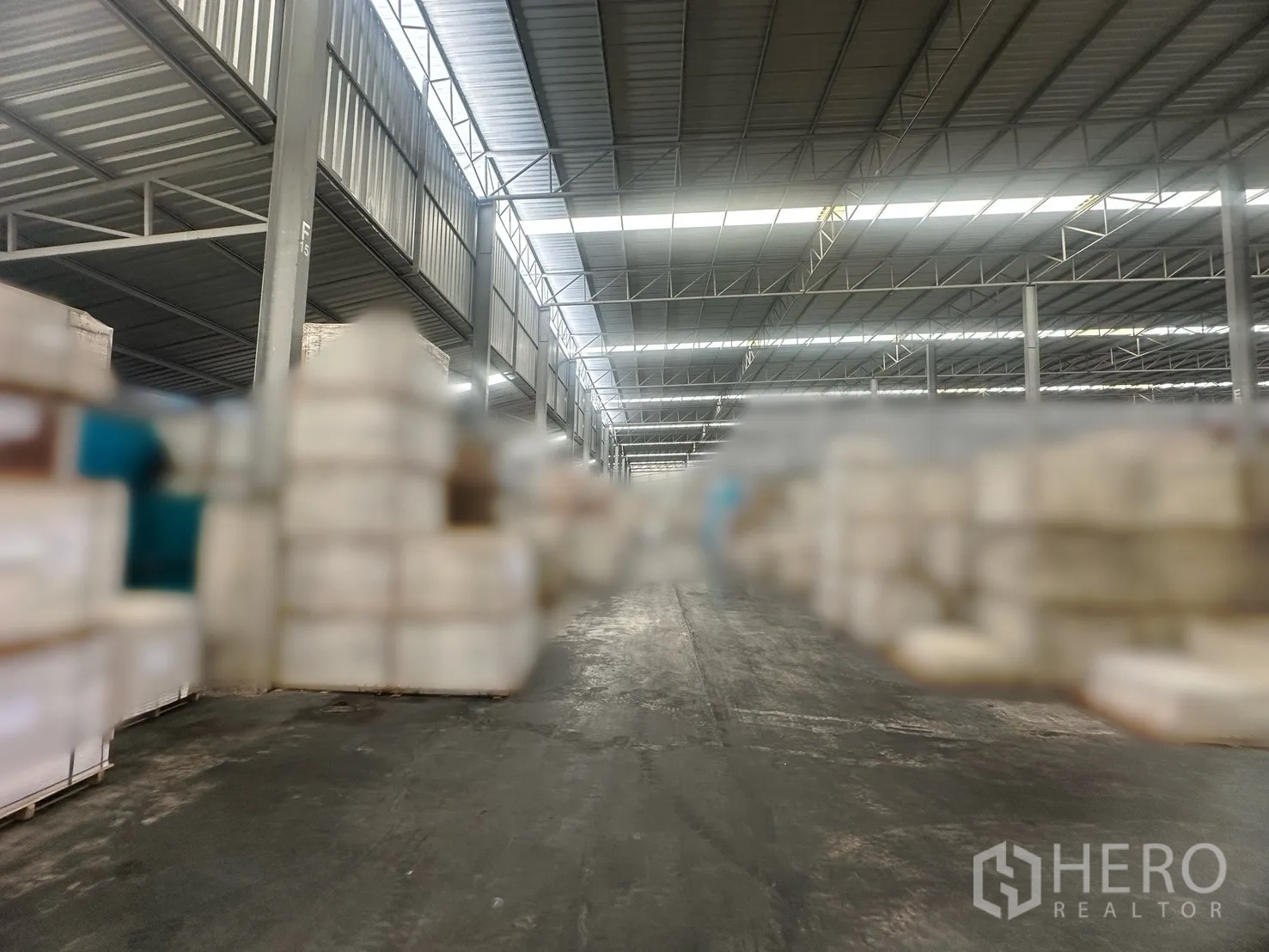 工厂 出租 - 高净空钢结构仓库内，货垛之间的宽阔通道。