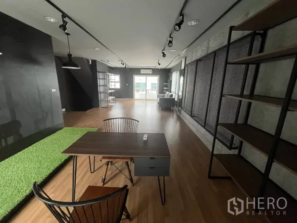Detached House for rent or sale in Don Mueang, Bangkok - Large loft‑style multipurpose room with track lights, desk and wood floors.