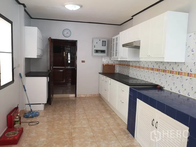 独立式住宅 出售 - 长廊式厨房，白色橱柜、花砖挡水板与宽敞操作台。