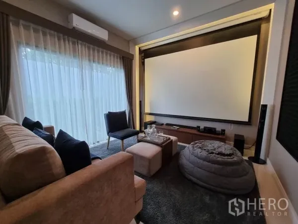 Detached House for rent in Prawet, Bangkok - Cozy home theater with large projector screen, plush seating and floor‑to‑ceiling curtains.