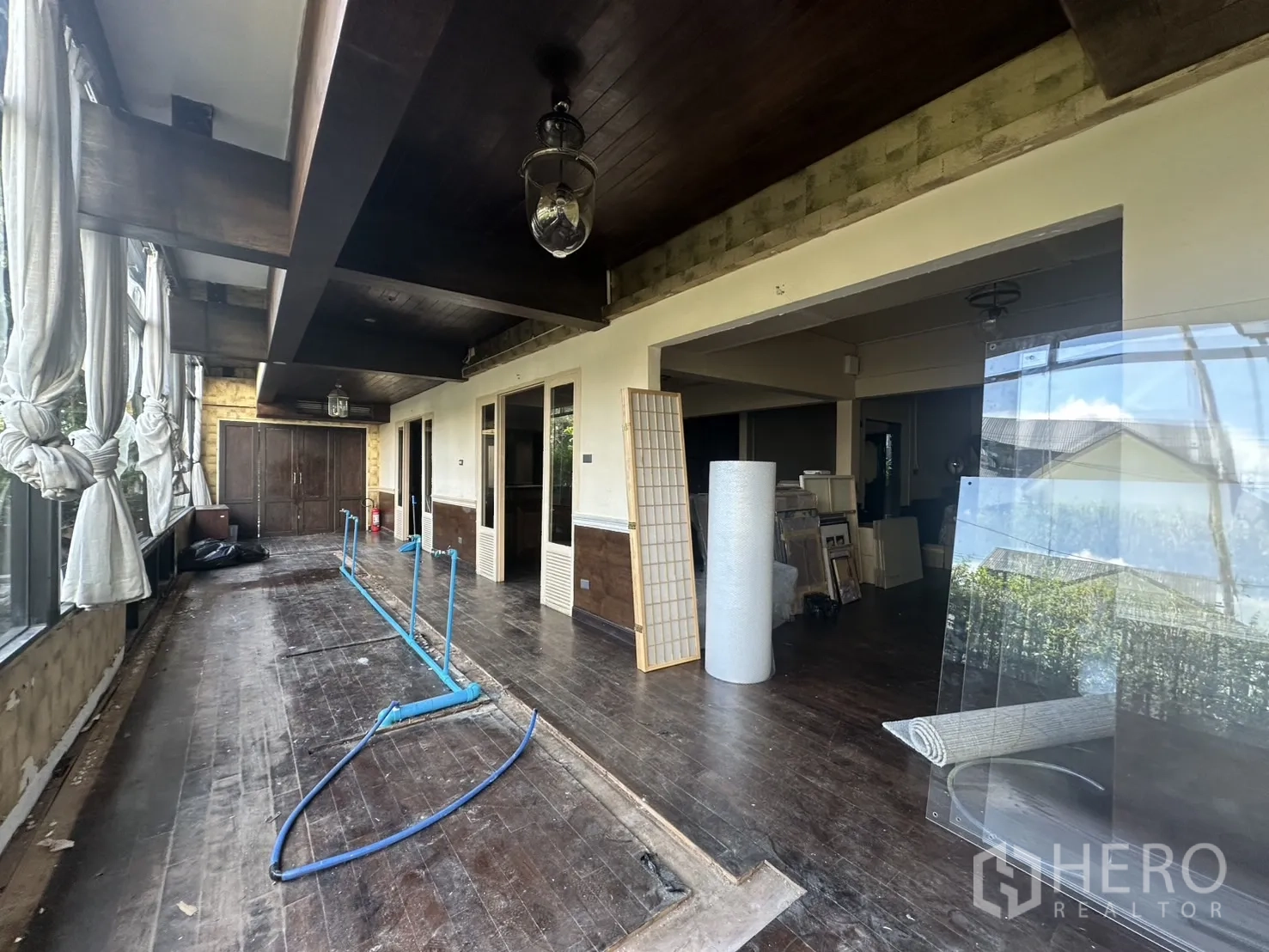 Detached House for rent - Broad terrace with timber ceiling and glass panels under light renovation.