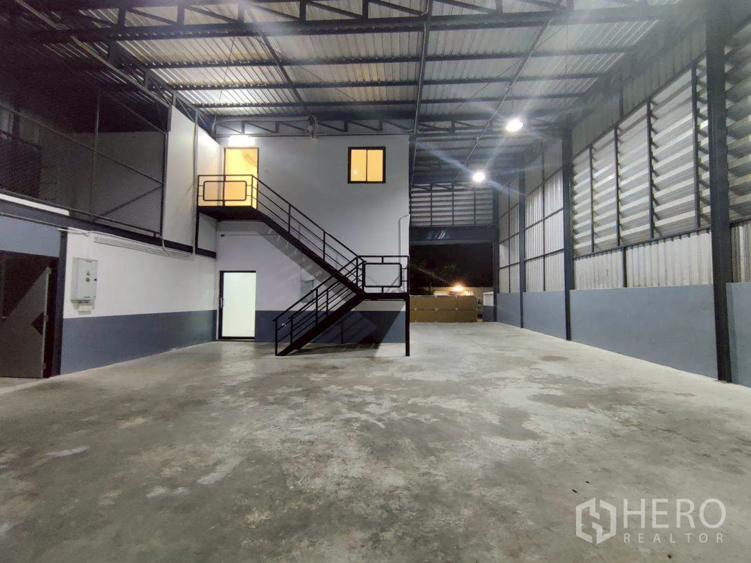 โกดัง for rent in Lam Luk Ka, Pathum Thani - ภายในโกดังเพดานสูง พื้นคอนกรีต และออฟฟิศชั้นลอยพร้อมบันไดเหล็ก.