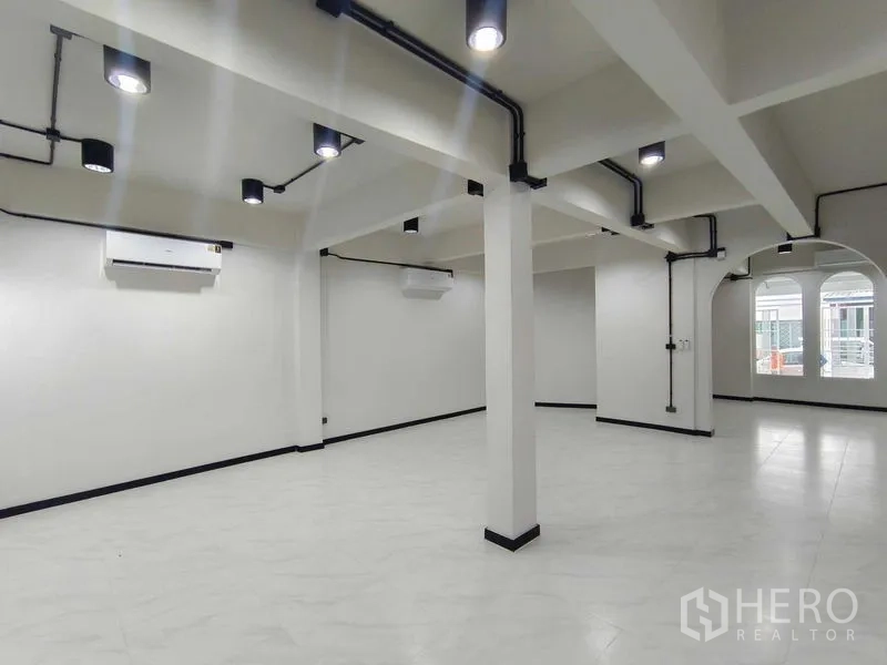 Townhouse for sale in Bang Phlat, Bangkok - Open-plan floor with columns, LED downlights, exposed conduits and air-conditioning.
