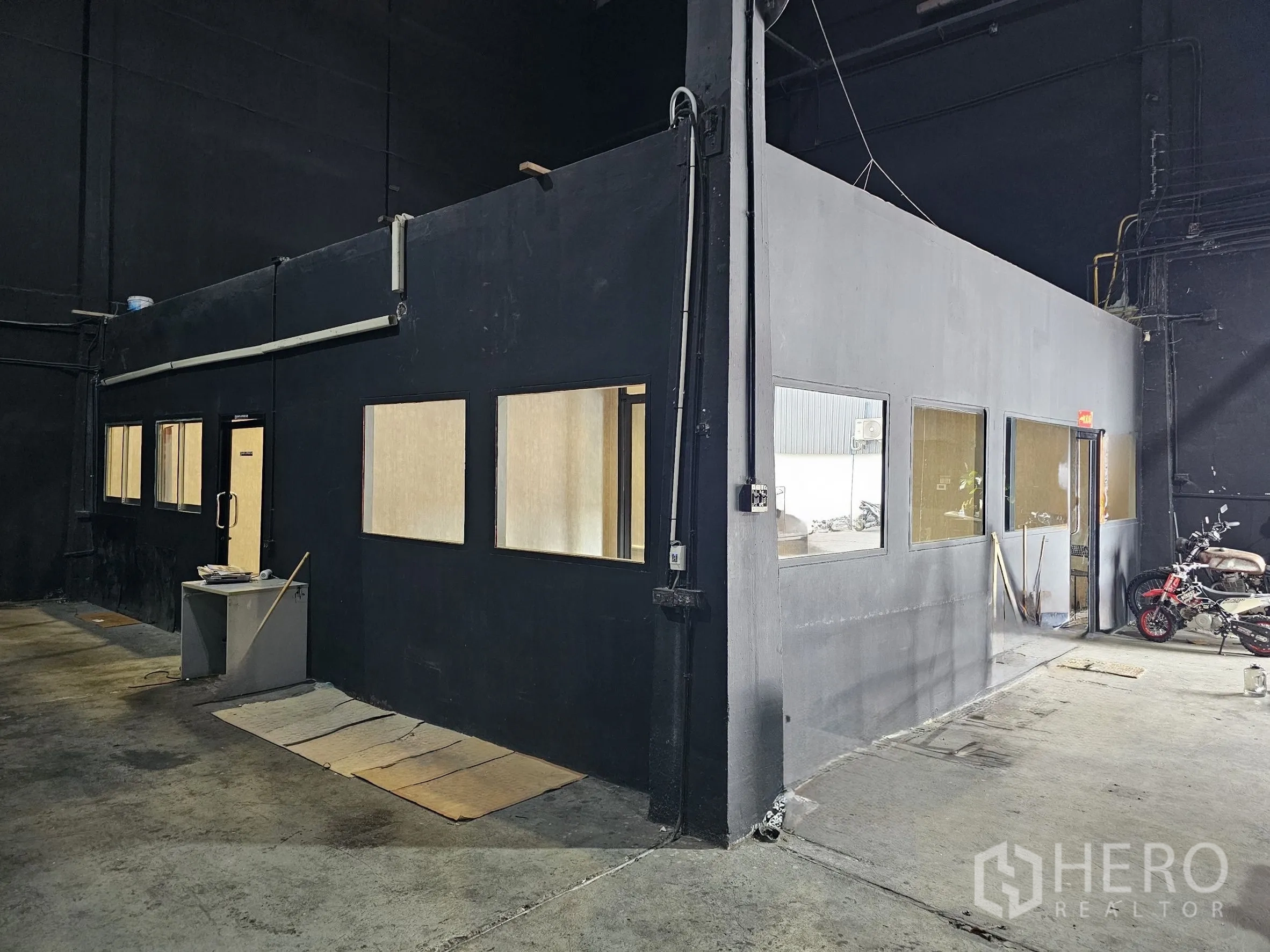 Warehouse for rent in Khlong Toei, Bangkok - Internal office unit with multiple windows and access doors inside the warehouse.