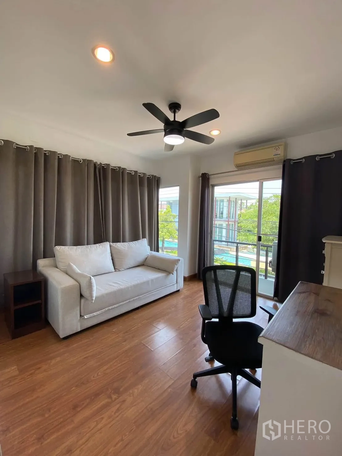 Detached House for rent in Mueang Samut Prakan, Samut Prakan - Corner room with sofa, desk, large windows, and balcony view.