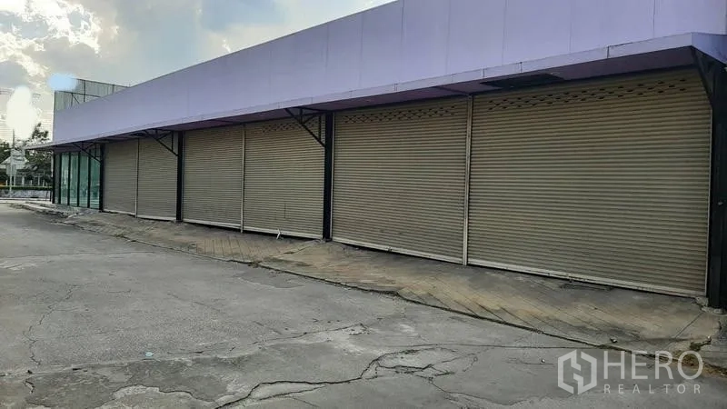 展厅 出租在Bueng Kum, Bangkok - 沿立面的多扇金属卷闸门与雨棚。