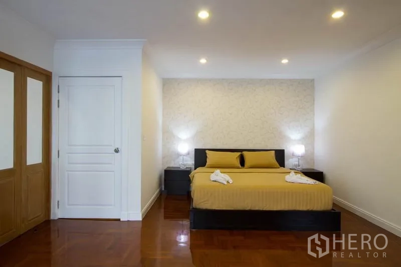 คอนโด ให้เช่าในWatthana, Bangkok - ห้องนอนมาสเตอร์กว้าง เตียงคิงไซซ์ โคมไฟหัวเตียง และพื้นปาร์เกต์