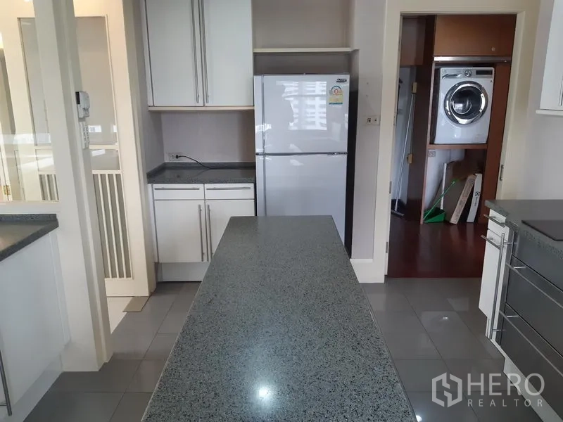 คอนโด ให้เช่าในKhlong Toei, Bangkok - ไอส์แลนด์ครัวหันไปทางตู้เย็น มีประตูสู่ห้องซักรีดแยก พร้อมเครื่องซักผ้าอบผ้าแบบวางซ้อน