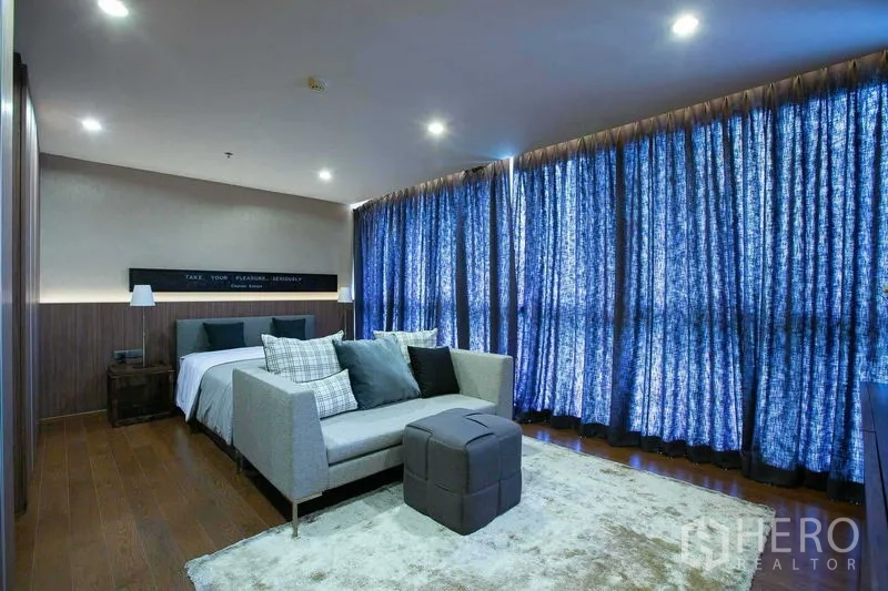 公寓 出售在Sathon, Bangkok - 大卧室带休闲区与木地板，厚遮光窗帘，曼谷公寓内部。