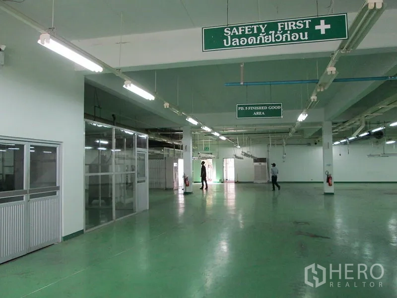 โรงงาน ให้เช่าในPathum Thani - ภายในโรงงานมีป้าย Safety First ห้องกระจกกั้น พื้นสีเขียว และแสงสว่างทั่วถึง