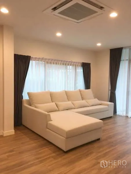 บ้าน ให้เช่าในBang Kapi, Bangkok - ห้องนั่งเล่นโปร่ง โซฟา L สีขาว หน้าต่างบานใหญ่ และแอร์ฝังฝ้า