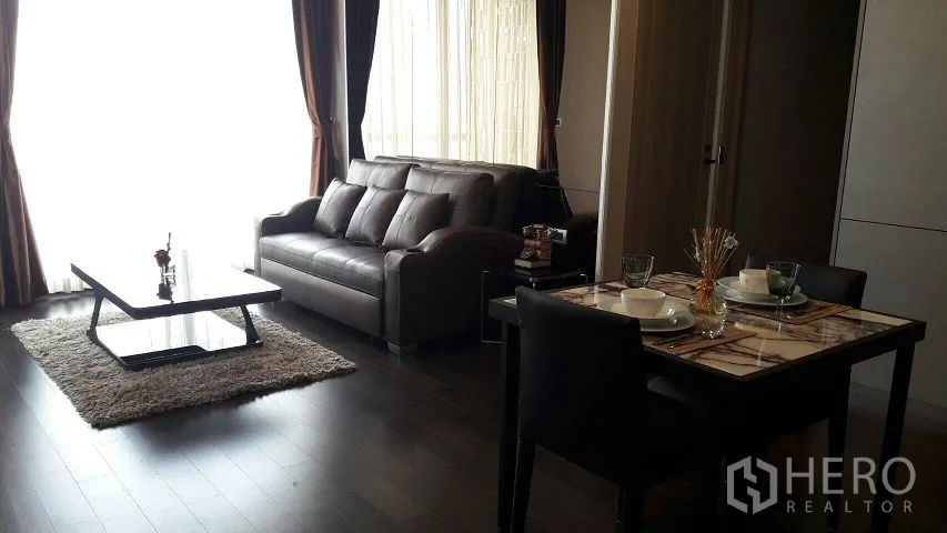 คอนโด ให้เช่าหรือขายในWatthana, Bangkok - ห้องนั่งเล่นและรับประทานอาหาร โซฟาหนัง โต๊ะท็อปหินอ่อน พื้นไม้เข้ม และหน้าต่างบานใหญ่