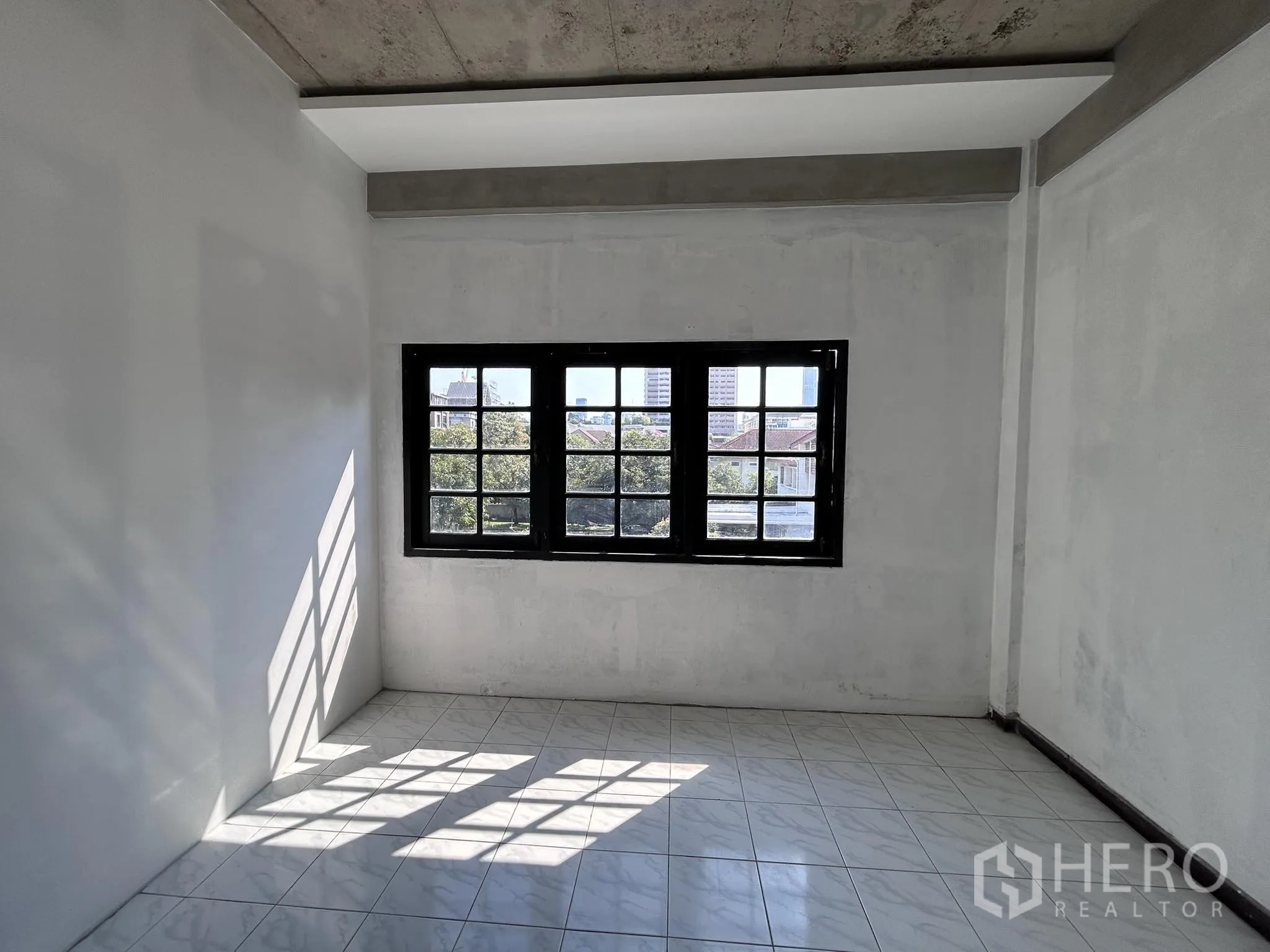 家庭办公室 for rent or sale in Watthana, Bangkok - 明亮瓷砖房，黑框窗与裸露混凝土梁。