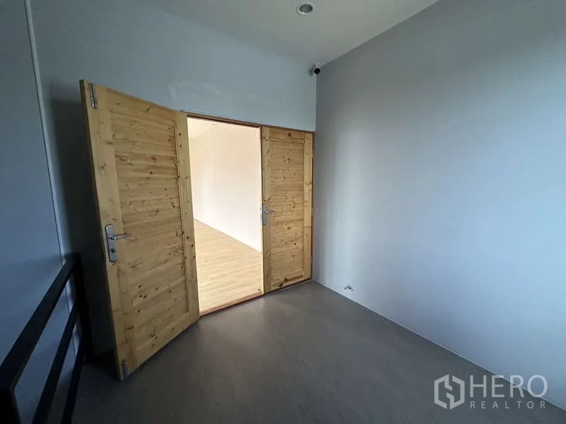 Factory for rent in Lam Luk Ka, Pathum Thani - Landing area with double wooden doors opening to an office room.