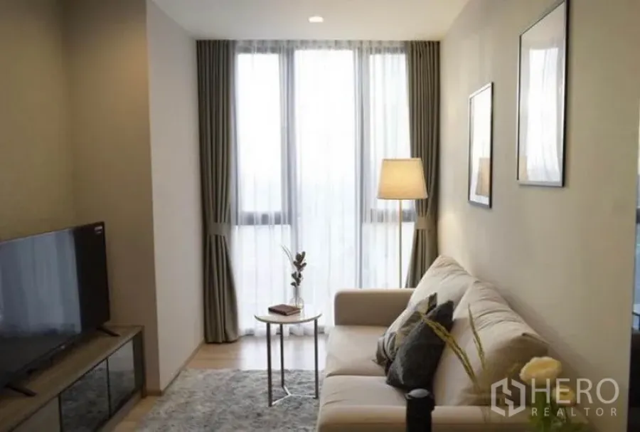 公寓 出租或出售在Phaya Thai, Bangkok - 帕亚泰公寓的采光客厅，配沙发、电视柜与落地窗。