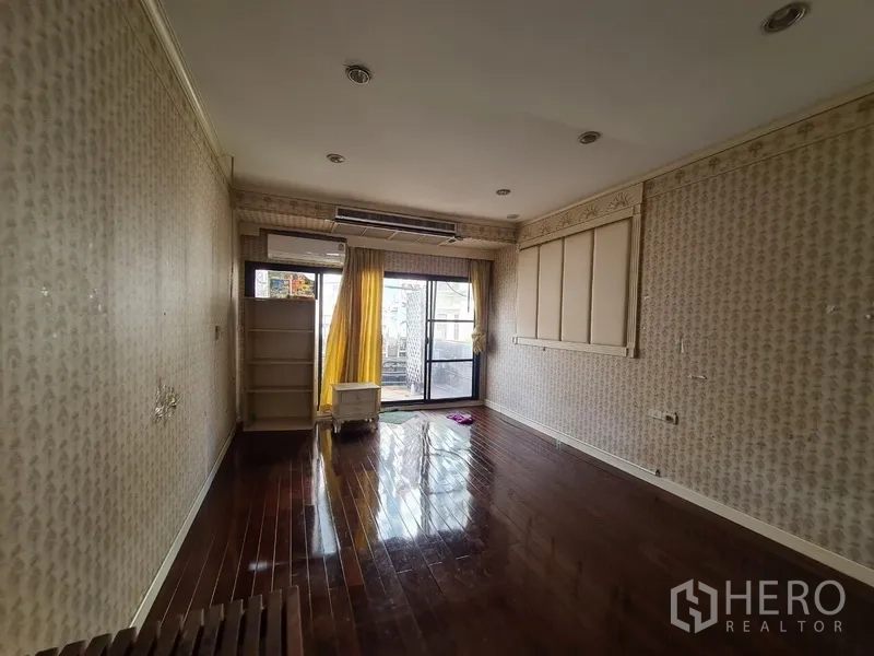 店屋 出租在Khlong Toei, Bangkok - 楼上房间带墙纸，推拉玻璃门通往阳台。