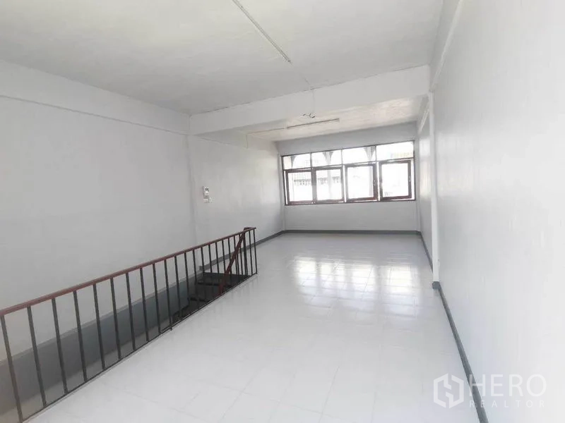 店屋 出租在Wang Thonglang, Bangkok - 旺通朗商住楼的明亮楼层，设大窗与楼梯扶手。