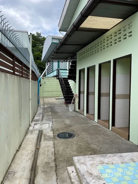 货栈 出租在Khan Na Yao, Bangkok - 建筑侧边设多间员工卫生间，走道上方有雨棚遮蔽。
