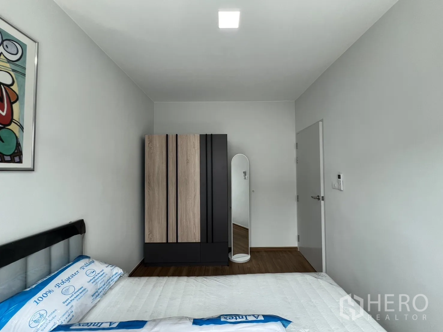Townhouse for rent in Bang Phli, Samut Prakan - Bright bedroom with a double bed, wood wardrobe and a full-length mirror.