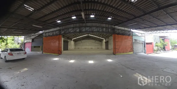 Warehouse for rent in Khlong Sam Wa, Bangkok - Covered loading bay leading to the main warehouse with large sliding doors and wide driveway.
