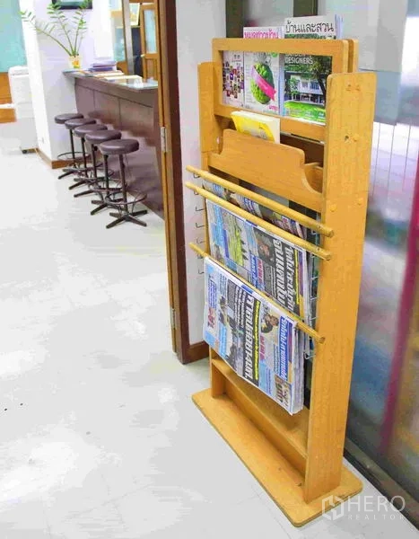 Office Space for rent in Lak Si, Bangkok - Lobby reading corner with a wooden magazine and newspaper rack beside bar stools.