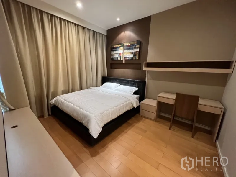 公寓 出租在Chatuchak, Bangkok - 卧室配特大床，重点墙面射灯，书桌与置物架及落地窗帘。