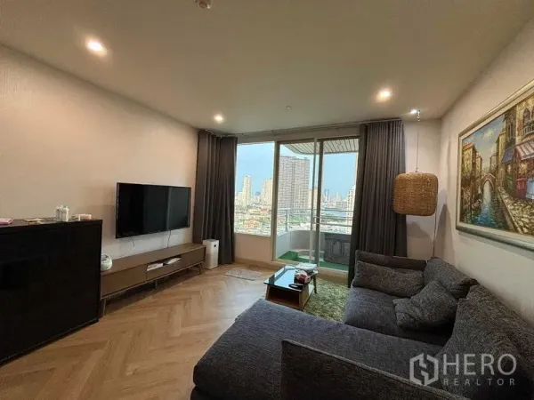 Condominium for rent - Living area viewing balcony and skyline through floor-to-ceiling glass doors.
