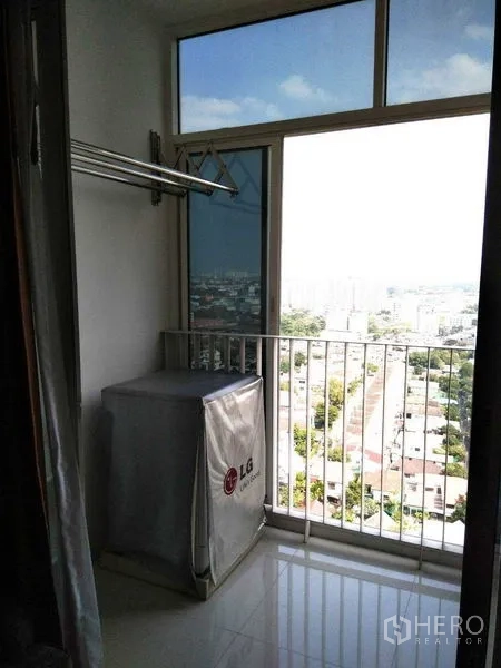 Condominium for rent in Watthana, Bangkok - Utility balcony with drying rack and washer cover facing a city panorama.