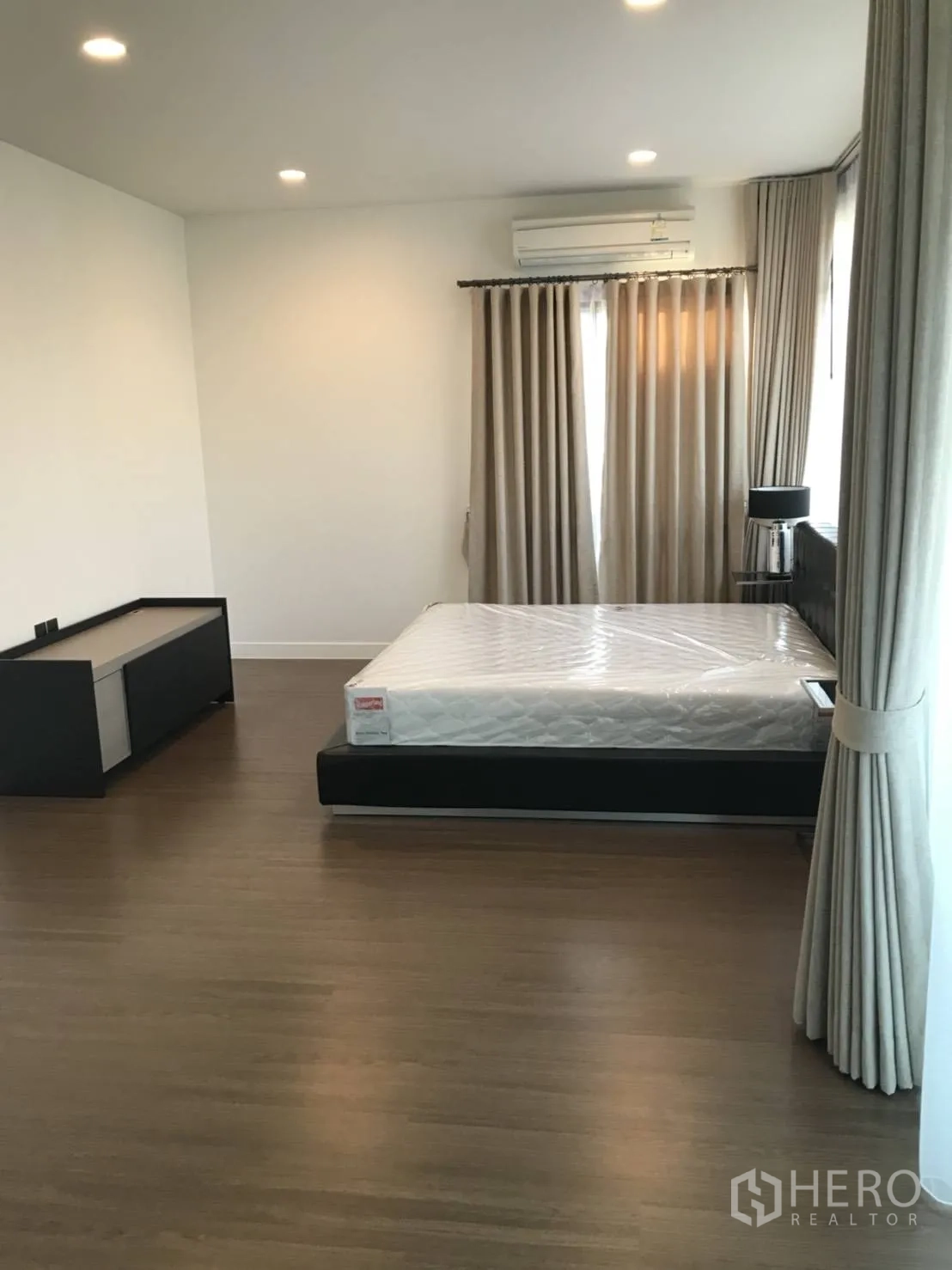 Detached House for rent in Bang Kapi, Bangkok - Spacious bedroom with double bed, recessed lighting and warm wood floors.