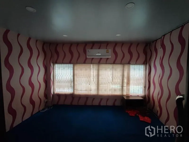Shophouse for rent in Khlong Toei, Bangkok - Room with pink wavy wallpaper, air conditioner and wide windows with blinds.