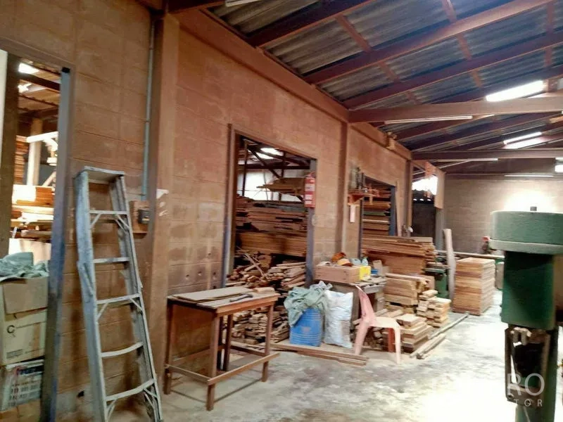 บ้าน ขายในBang Na, Bangkok - โถงเวิร์กชอปมีบันไดพาด กองไม้ และผนังคอนกรีตใต้หลังคาเมทัลชีท