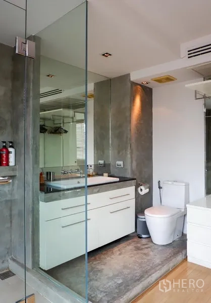 คอนโด ให้เช่าหรือขายในKhlong Toei, Bangkok - ห้องน้ำสไตล์โมเดิร์น มีฉากกั้นอาบน้ำกระจก เคาน์เตอร์อ่างล้างหน้า และผิวคอนกรีต.