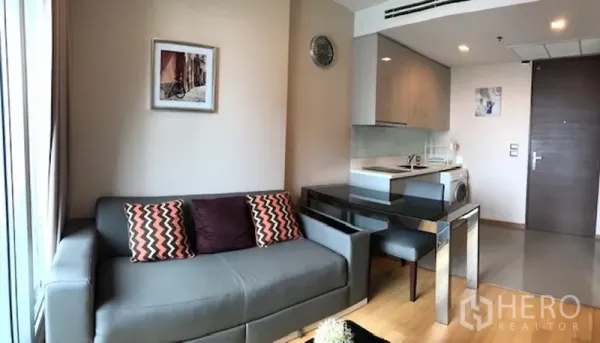 公寓 出租在Ratchathewi, Bangkok - 开放式客厅，沙发与餐桌相连，入门处为紧凑厨房