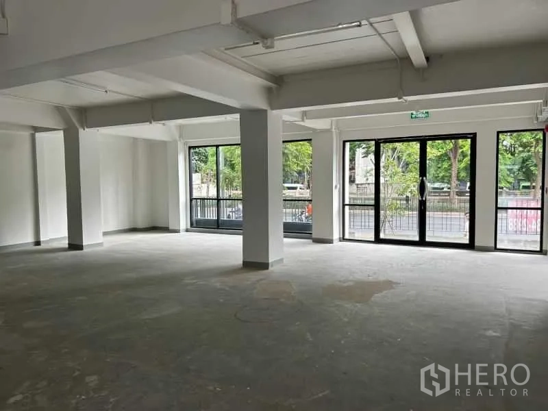 办公空间 出租在Bang Rak, Bangkok - 一层临街展示空间，宽幅推拉玻璃门通向外部。