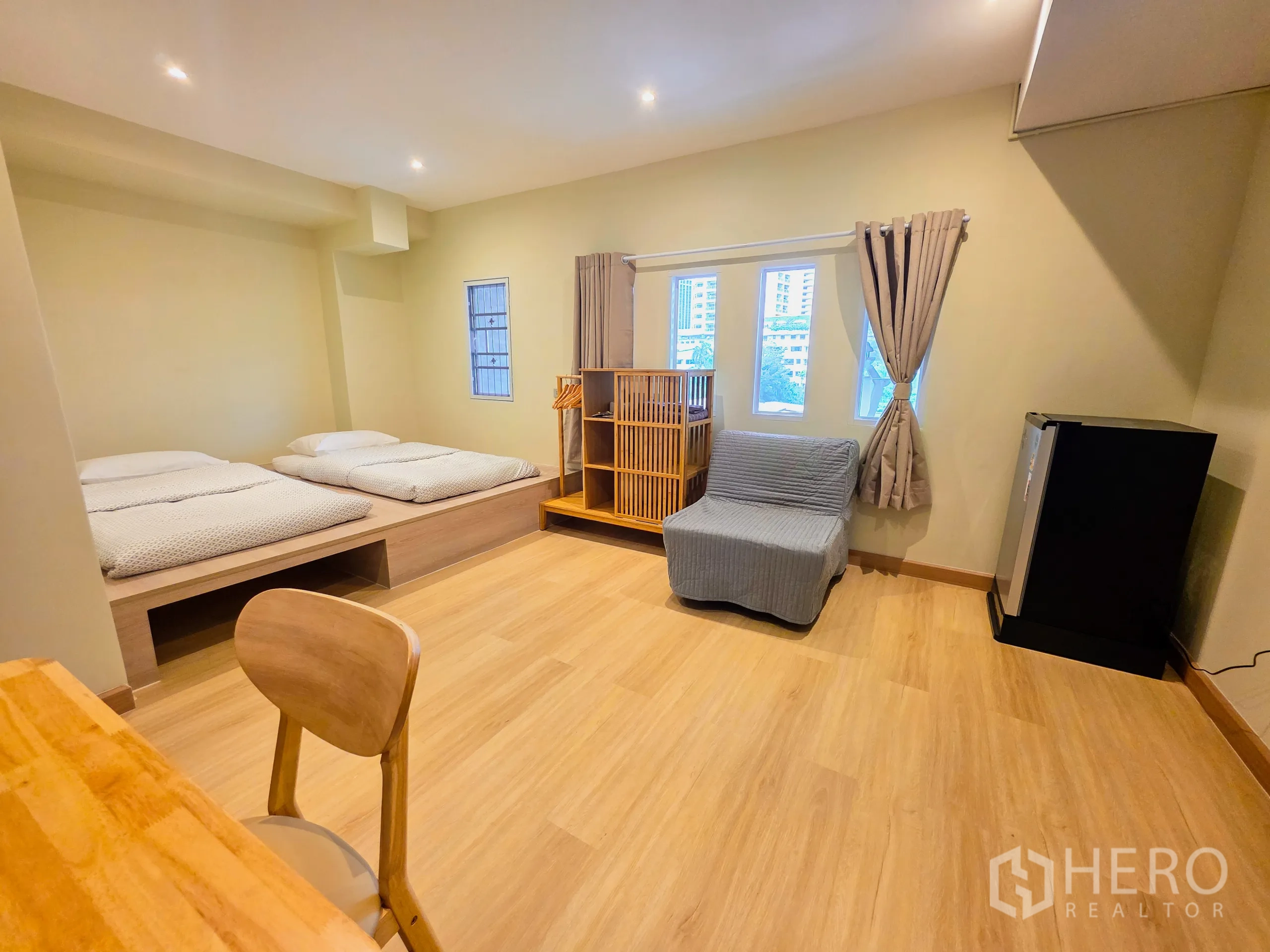 อาคารพาณิชย์ ให้เช่าในWatthana, Bangkok - ห้องกว้าง เตียงคู่ยกพื้น หน้าต่าง และตู้เย็นเล็ก