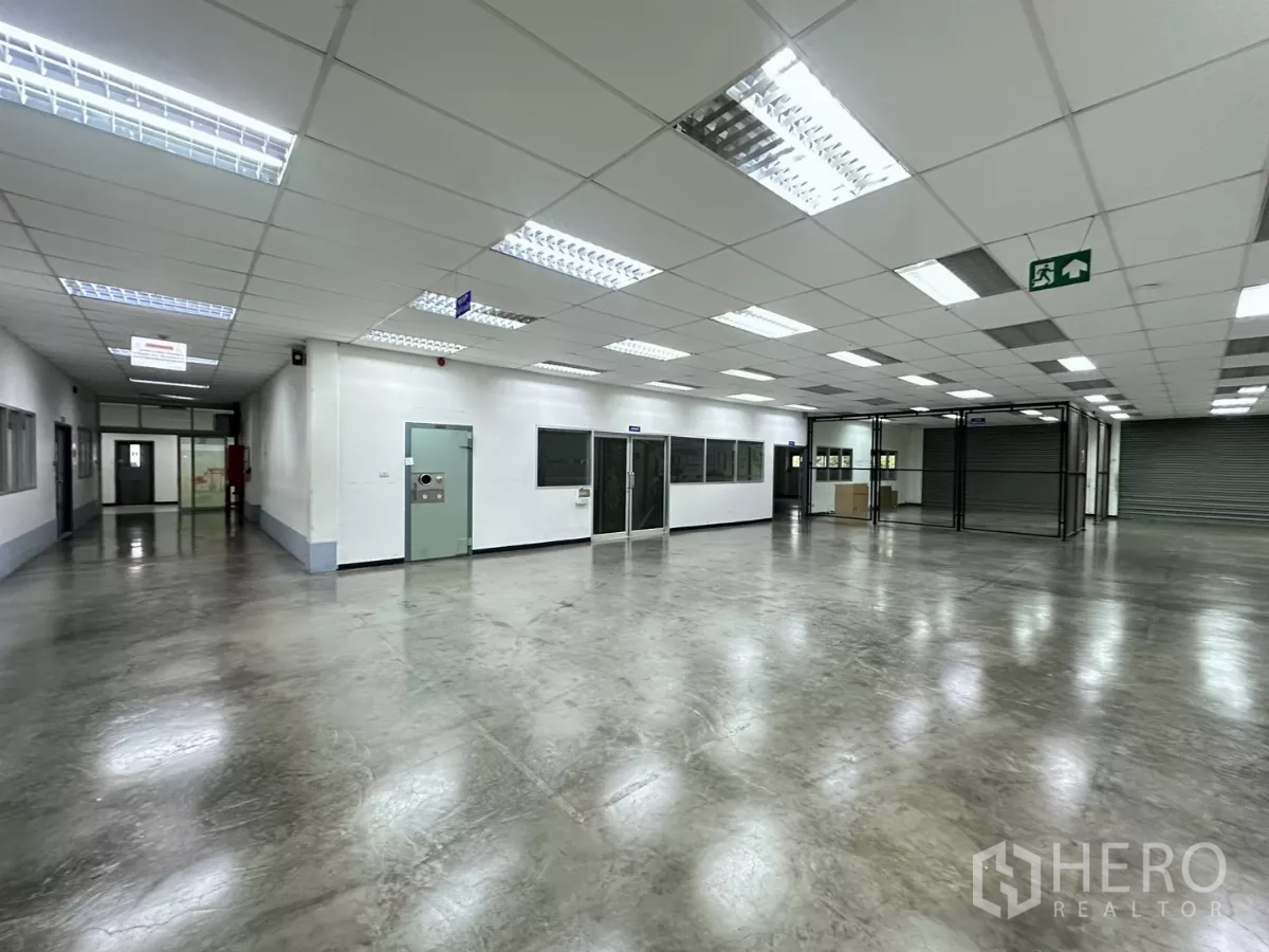 โรงงาน ขายในLat Krabang, Bangkok - โถงทำงานพร้อมออฟฟิศกั้นกระจก ป้ายความปลอดภัย และประตูม้วน