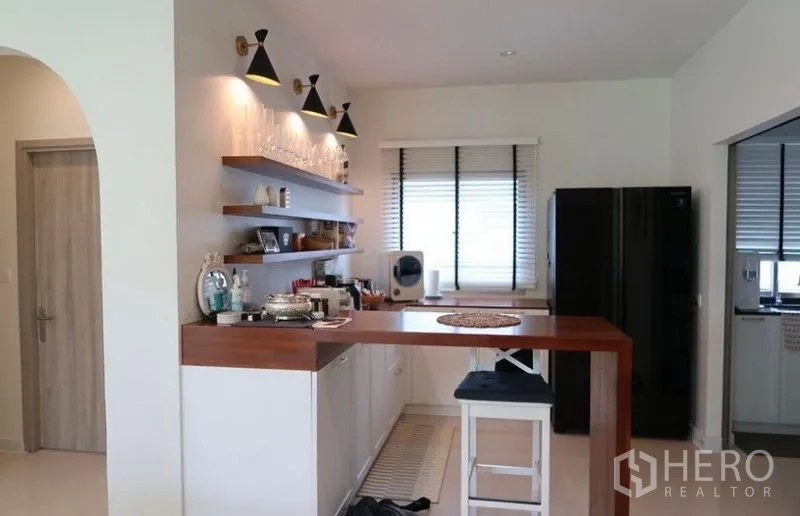 Detached House for rent or sale in Saphan Sung, Bangkok - Pantry and breakfast bar with open shelves, wood counter, and modern sconces.