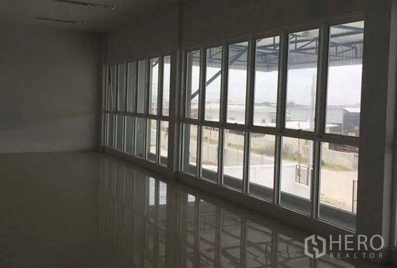 货栈 出租在Bang Bo, Samut Prakan - 落地窗办公室，俯瞰仓库前院与周边景观。