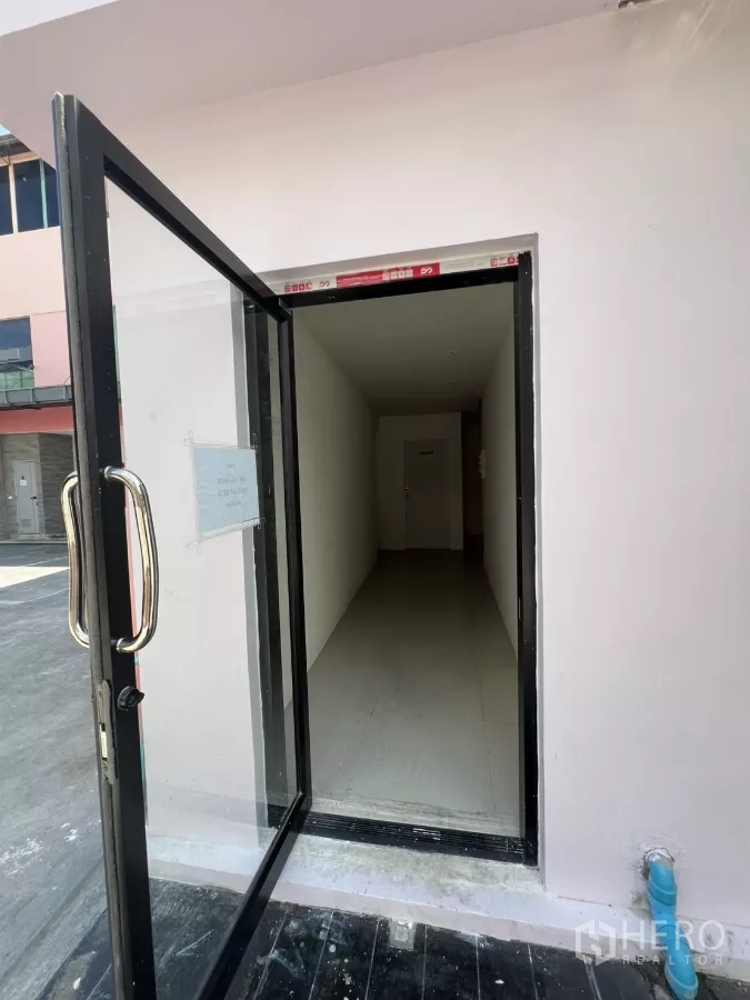 พื้นที่ขายปลีก ให้เช่า - ประตูกระจกเปิดสู่โถงแคบผนังขาว