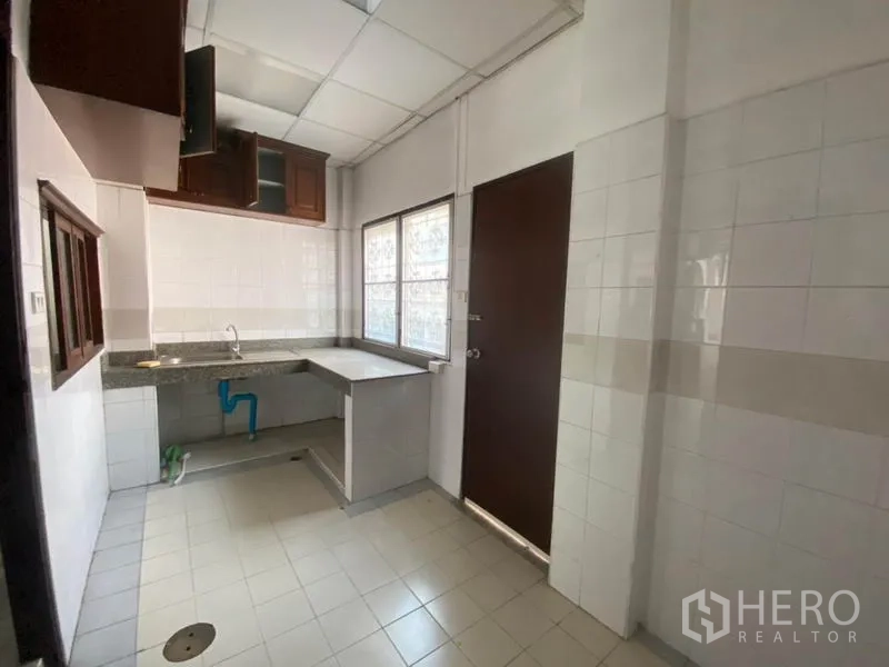 ทาวน์เฮาส์ ให้เช่าในWatthana, Bangkok - ครัวปูกระเบื้องขนาดกะทัดรัด มีเคาน์เตอร์ อ่างล้าง และตู้แขวน.