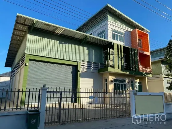 โรงงาน ให้เช่าหรือขายในLam Luk Ka, Pathum Thani - ภายนอกโรงงานสไตล์โมเดิร์นในลำลูกกา ผนังเมทัลชีทสีเขียว ประตูม้วนขนาดใหญ่และอาคารสำนักงานพร้อมรั้วรอบขอบชิด