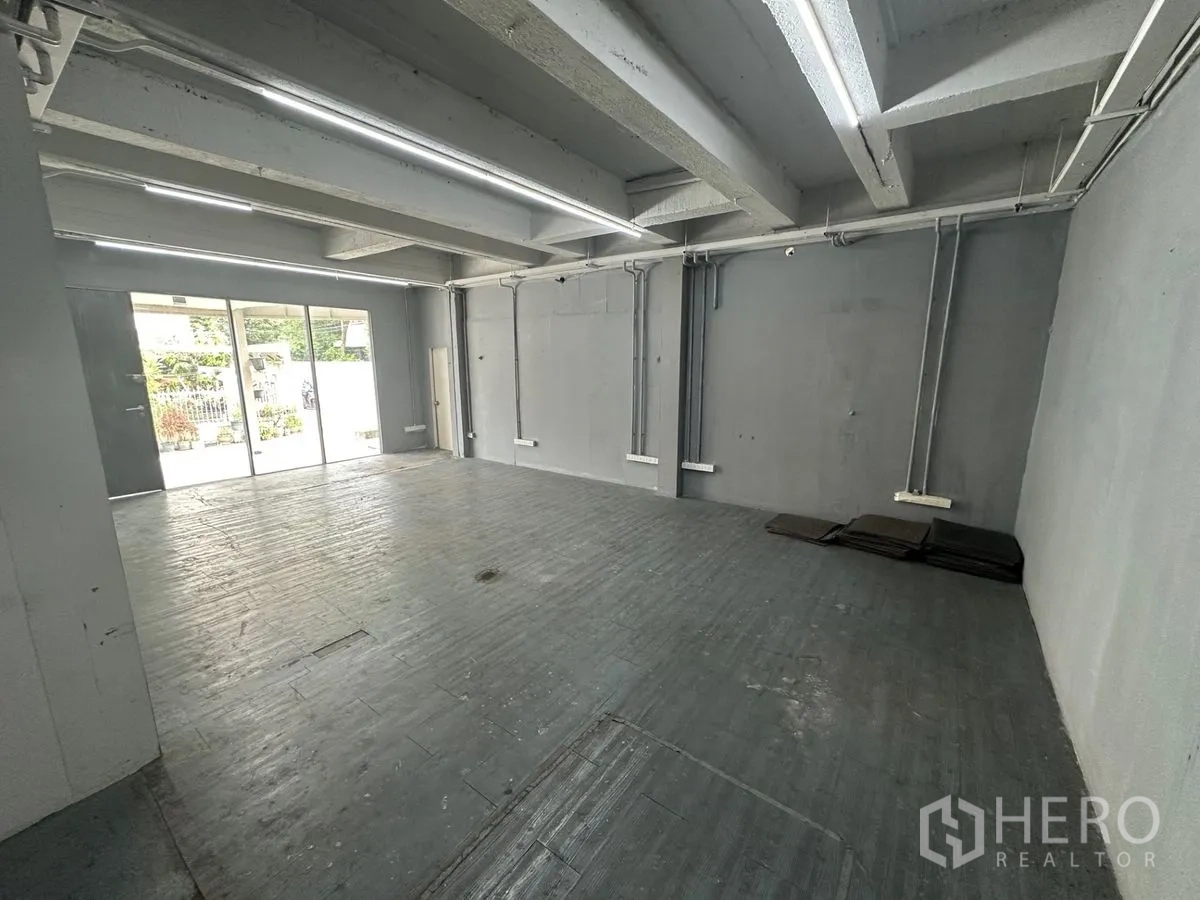 带办公室的家 出租在Chatuchak, Bangkok - 一层开放空间，推拉玻璃门与长条照明。