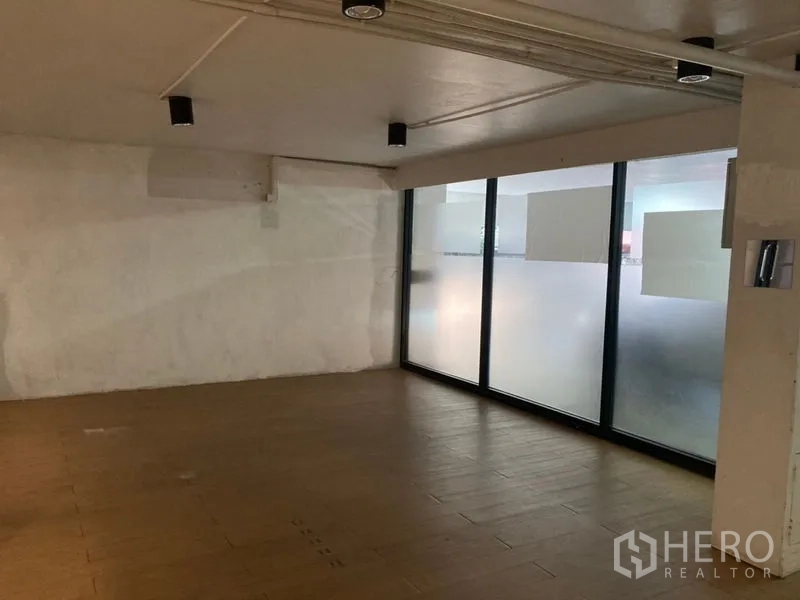 零售空间 出租在Khlong Toei, Bangkok - 后部安静区，白色质感墙面与磨砂窗带来柔和采光。